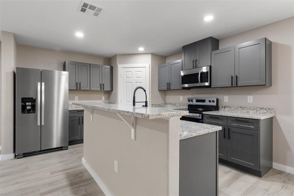 1905 Sanger Avenue Waco, TX 76707 - Photo 5 of 21 a kitchen with stainless steel appliances granite countertop a refrigerator stove microwave and sink