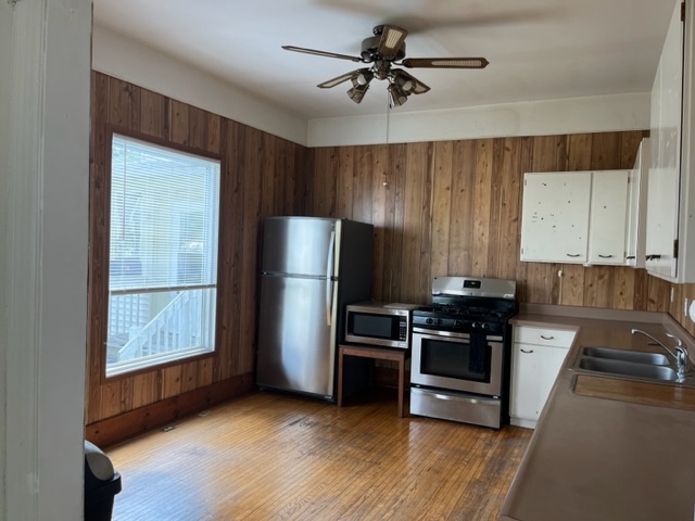 912 North 6th Street Rochelle, IL 61068 - Photo 7 of 34 a kitchen with a refrigerator a stove a microwave cabinets and wooden floor