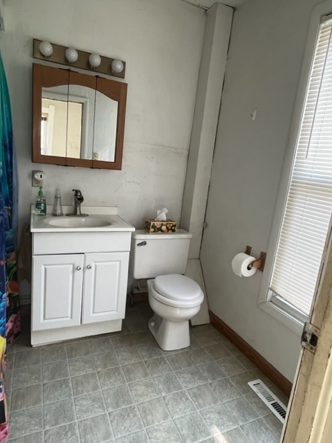 912 North 6th Street Rochelle, IL 61068 - Photo 9 of 34 a bathroom with a toilet a sink a vanity and mirror