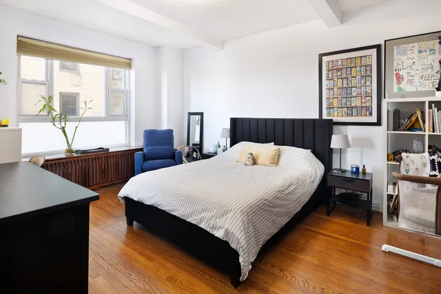 a bedroom with a bed window and a table in it