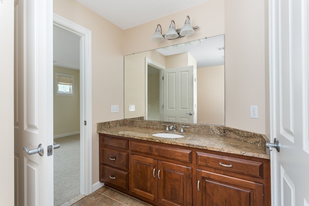 49 Beaver Street, Unit 49 Franklin, MA 02038 - Photo 22 of 46 a bathroom with a granite countertop sink and a mirror