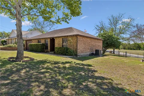 a view of a house with backyard and tree