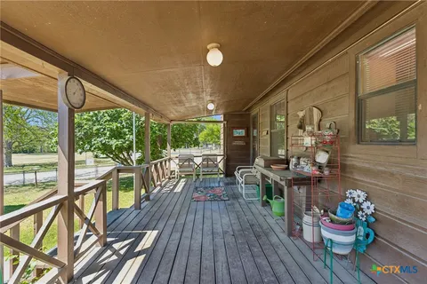 a view of a porch with furniture and wooden floor