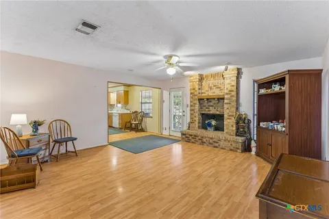 a view of a livingroom with furniture a fireplace and wooden floor