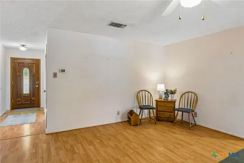 a view of a room with wooden floor and furniture