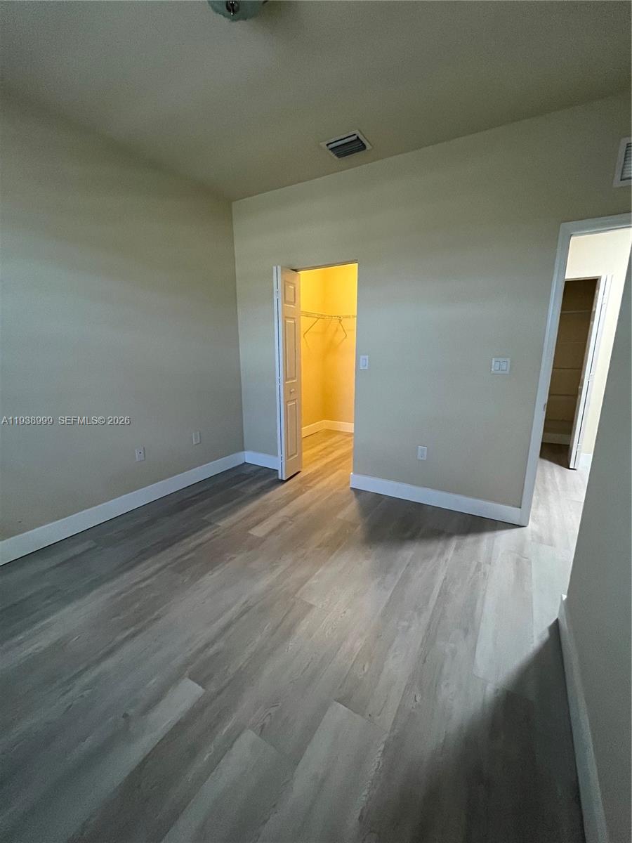 23218 Southwest 113 Passage Homestead, FL 33032 - Photo 15 of 23 an empty room with a wooden floor and door