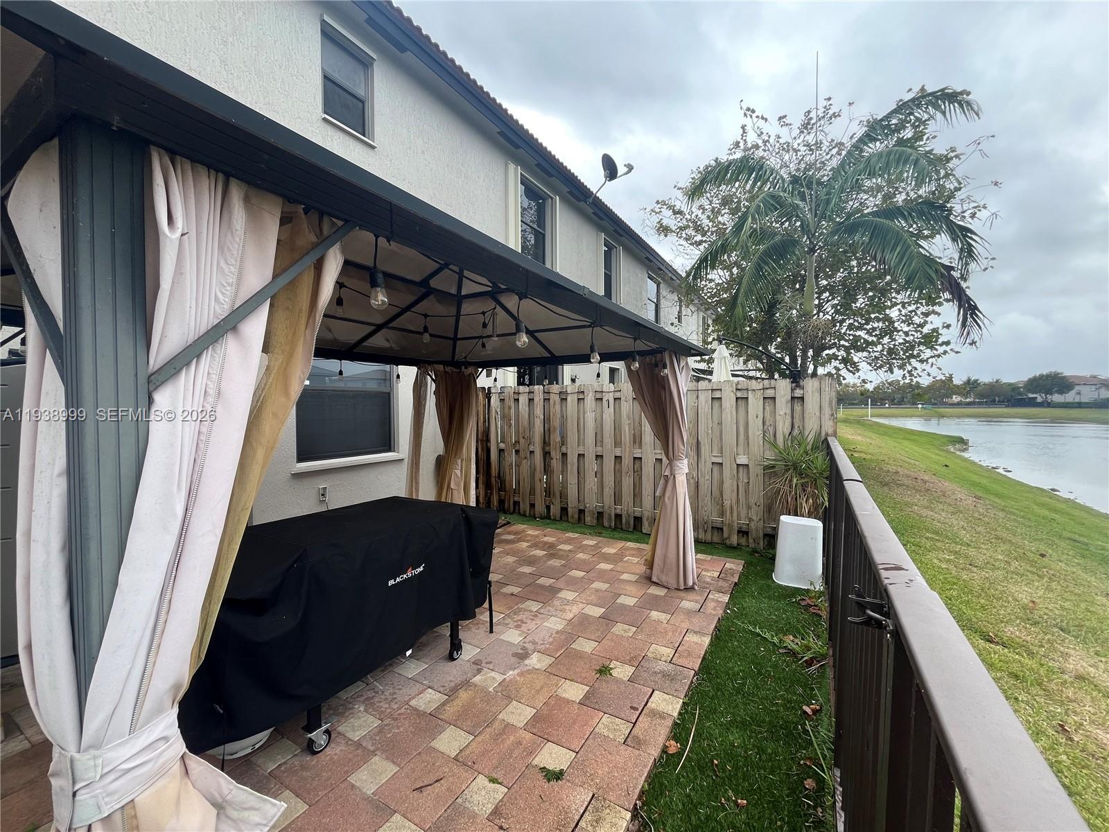 23218 Southwest 113 Passage Homestead, FL 33032 - Photo 20 of 23 a backyard of a house with wooden floor and outdoor seating