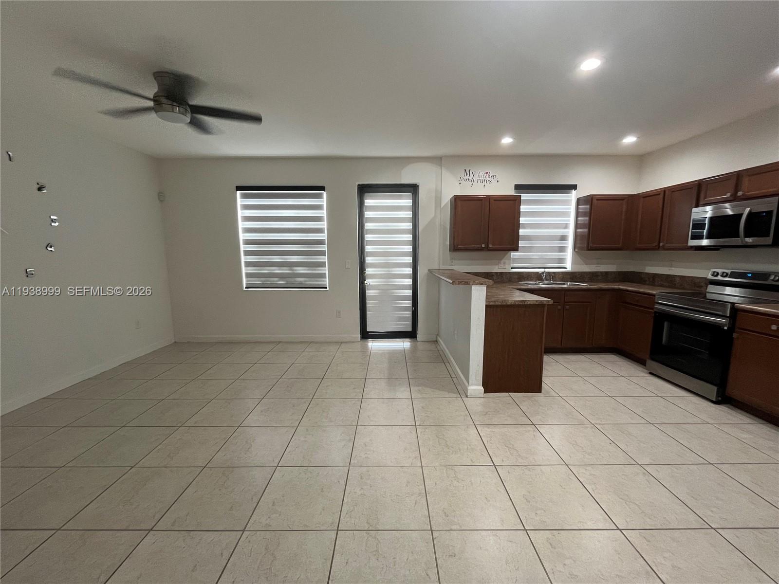 23218 Southwest 113 Passage Homestead, FL 33032 - Photo 6 of 23 a kitchen with stainless steel appliances granite countertop a stove and a sink