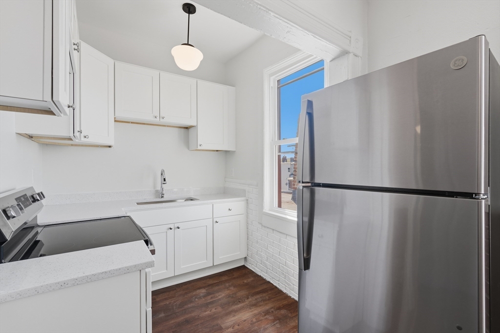 a kitchen with a refrigerator a sink and cabinets