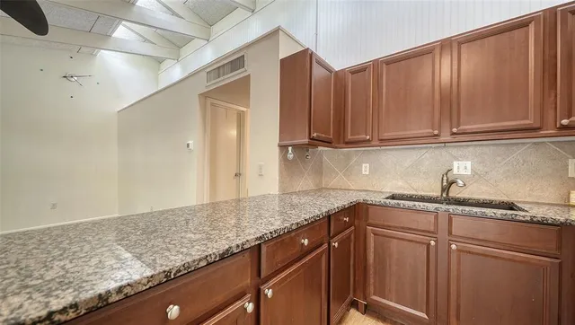 a kitchen with granite countertop cabinets and refrigerator