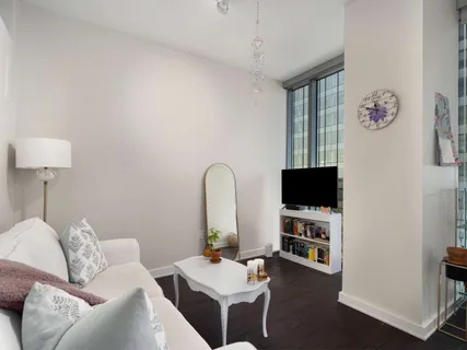 a living room with furniture a flat screen tv and a window