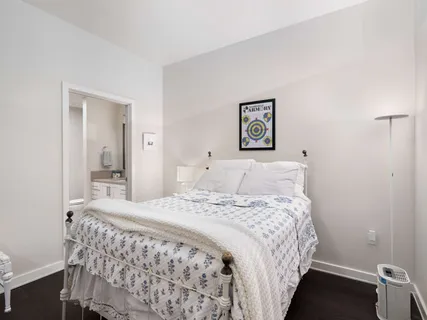 a bedroom with a bed and a painting on the wall