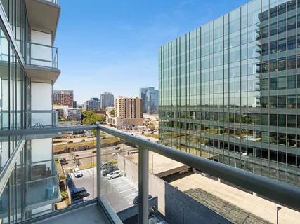 a view of balcony with a couple of cars parked in parking lot