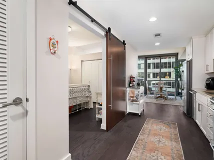 a walk in closet with view of living room