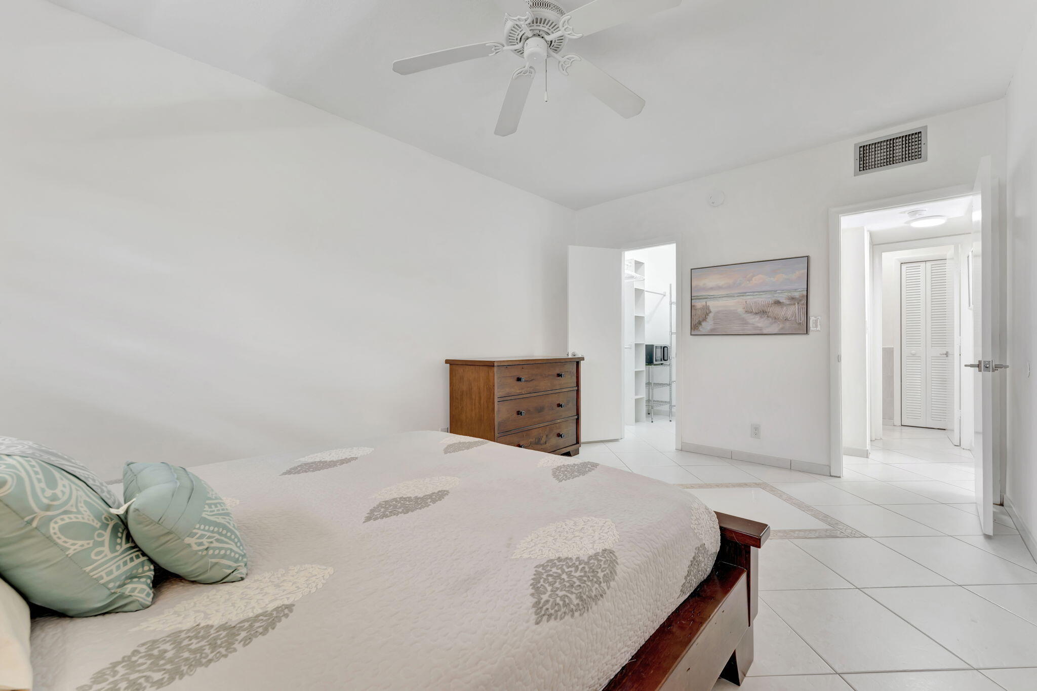 1450 North Riverside Drive, Unit 103 Pompano Beach, FL 33062 - Photo 16 of 34 a bedroom with a bed and ceiling fan