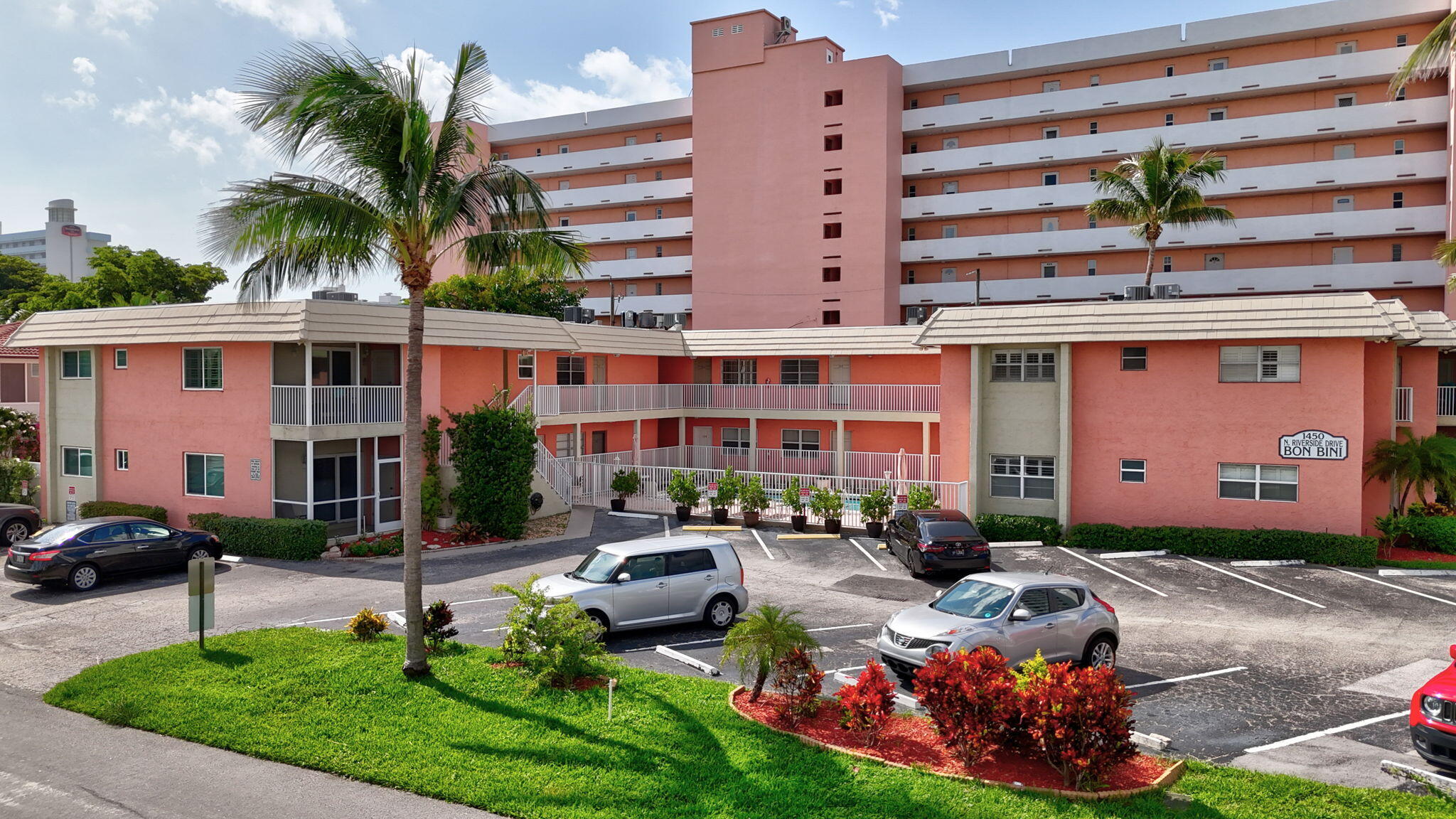 1450 North Riverside Drive, Unit 103 Pompano Beach, FL 33062 - Photo 4 of 34 a front view of a building with garden and parking