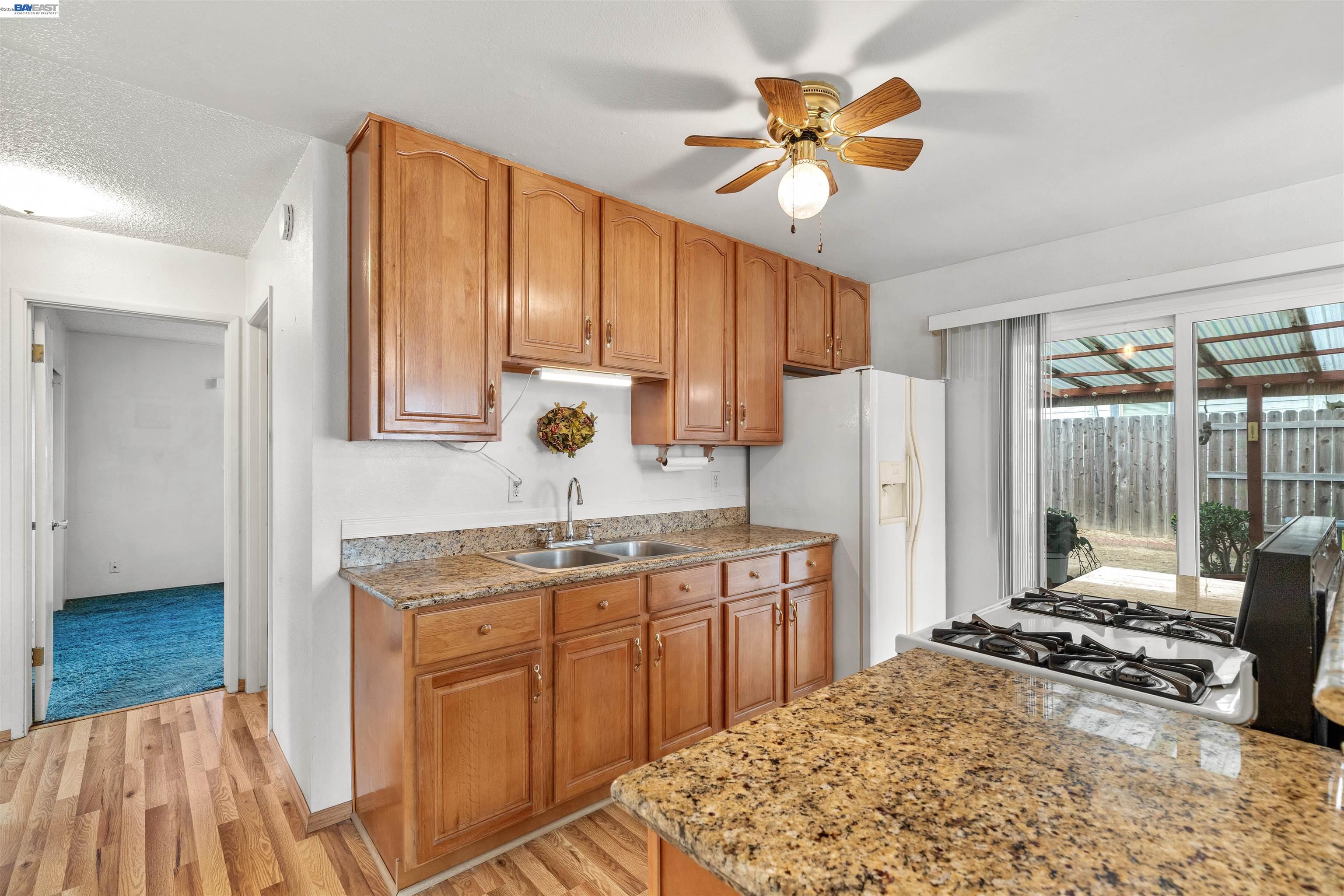 953 Thomsen Road Lathrop, CA 95330 - Photo 17 of 49 a kitchen with a stove a refrigerator a sink and white cabinets