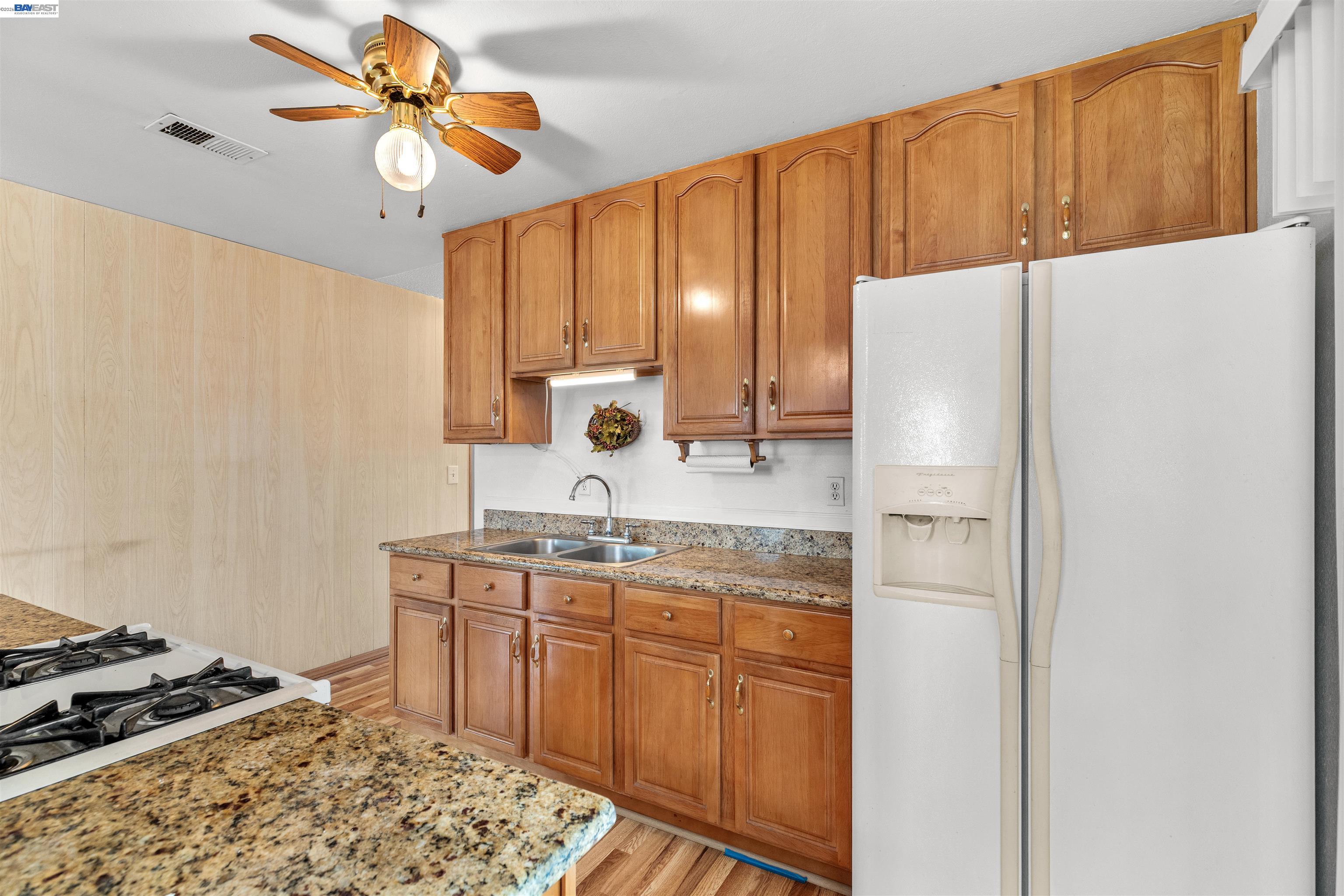 953 Thomsen Road Lathrop, CA 95330 - Photo 20 of 49 a kitchen with a sink a refrigerator and a stove top oven