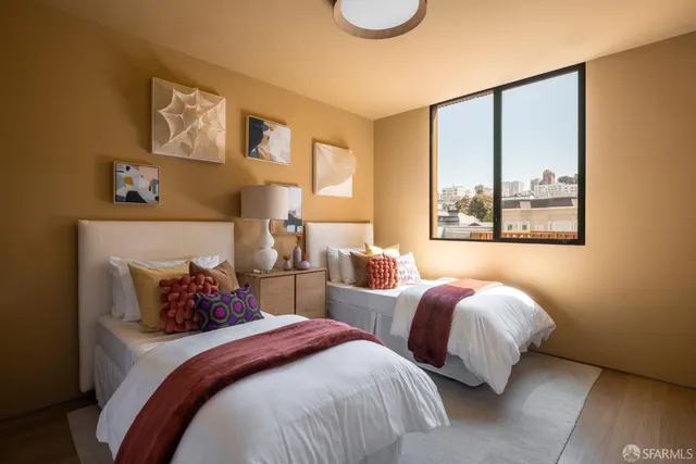 a bedroom with two beds and painting on the wall