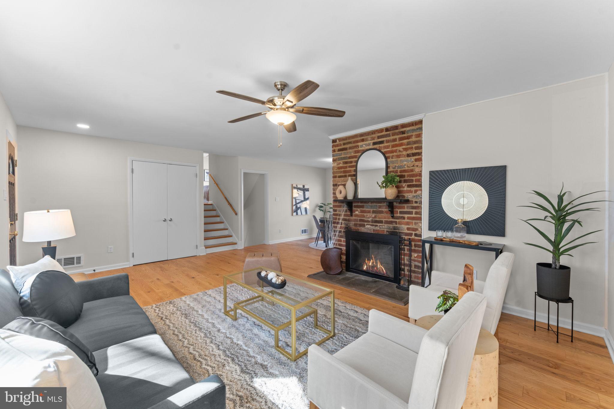 7448 Long Pine Drive Springfield, VA 22151 - Photo 7 of 40 a living room with furniture a fireplace a clock and a flat screen tv