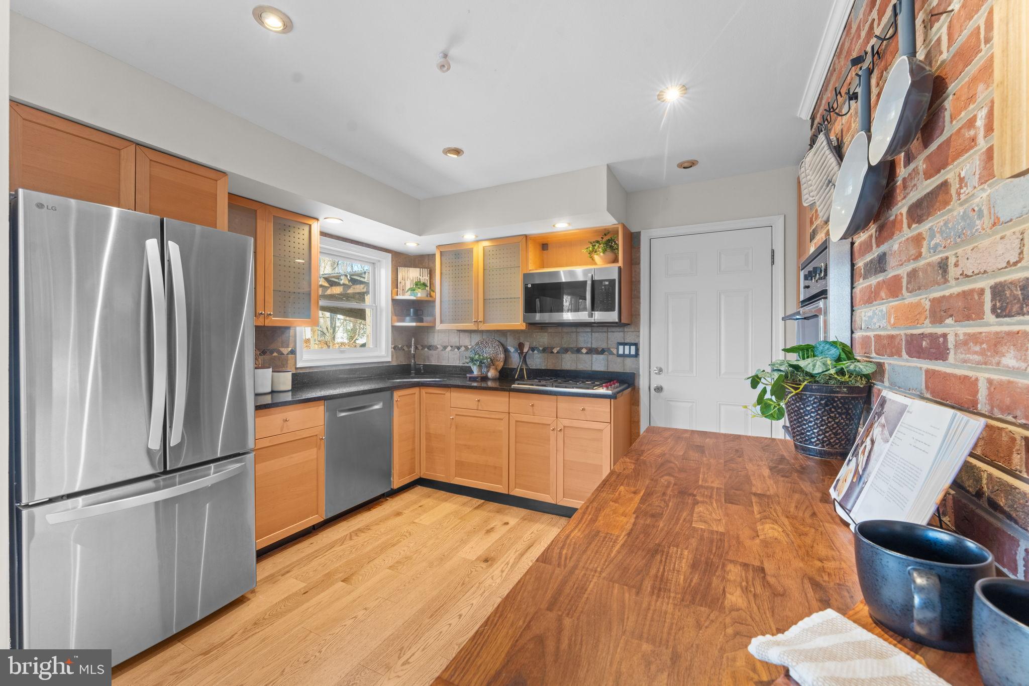 7448 Long Pine Drive Springfield, VA 22151 - Photo 10 of 40 a kitchen with stainless steel appliances a refrigerator a sink a stove white cabinets and wooden floor