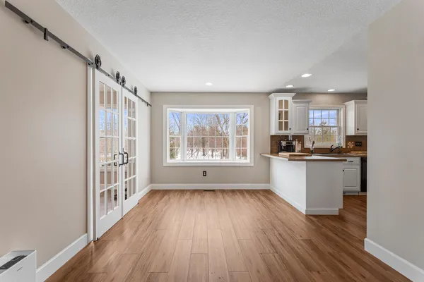 a view of a kitchen with wooden floor and a window