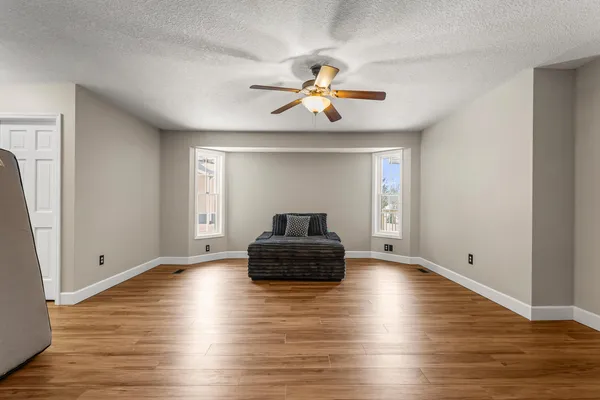 a living room with hard wood floors and a ceiling fan