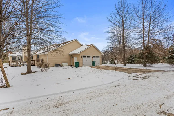 a view of white house with a yard covered in snow