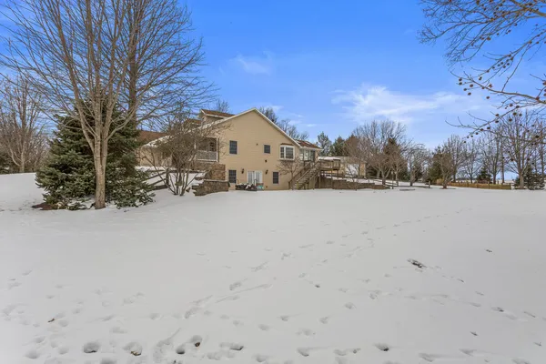a view of large house with a yard covered with snow in front of house