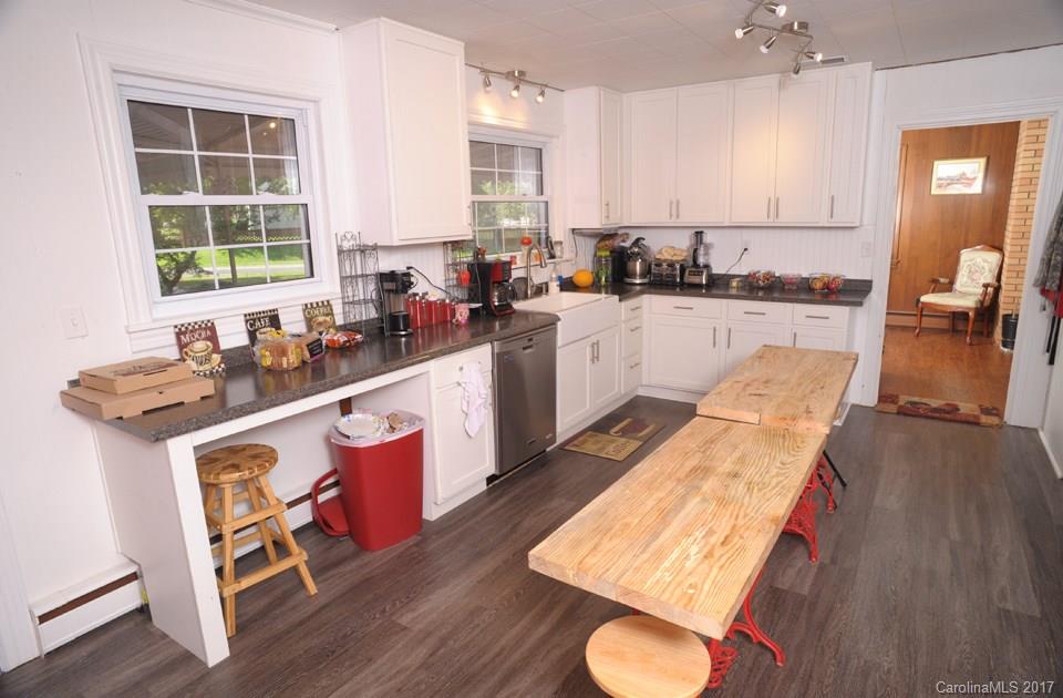 7135 Pop Basinger Road Salisbury, NC 28146 - Photo 10 of 23 a open kitchen with stainless steel appliances granite countertop a stove a sink dishwasher and a dining table with wooden floor