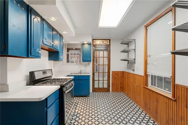 a kitchen with stainless steel appliances a stove a refrigerator a sink a counter top space and cabinets