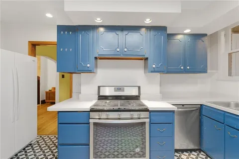 a kitchen with a sink a stove a refrigerator and cabinets