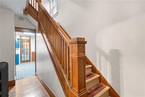 a view of staircase with wooden floor and white walls