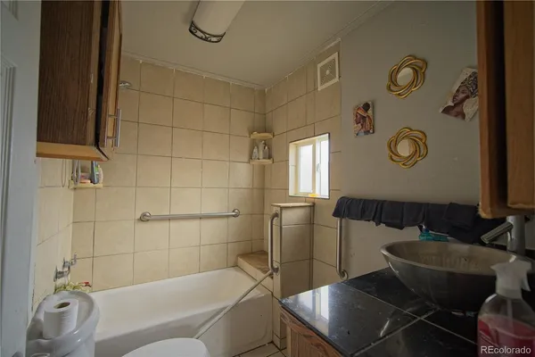 a bathroom with a tub sink and mirror