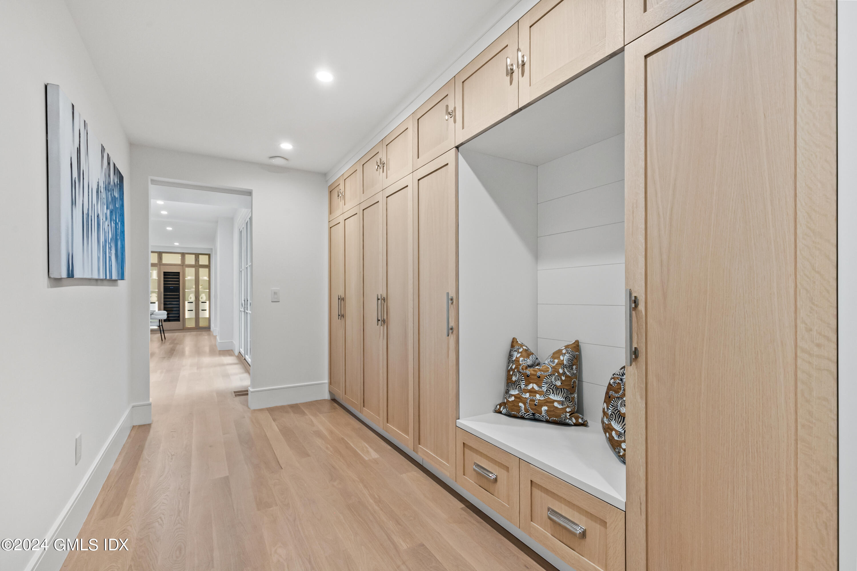 248 Round Hill Road Greenwich, CT 06831 - Photo 16 of 49 a view of a hallway with wooden floor and cabinet