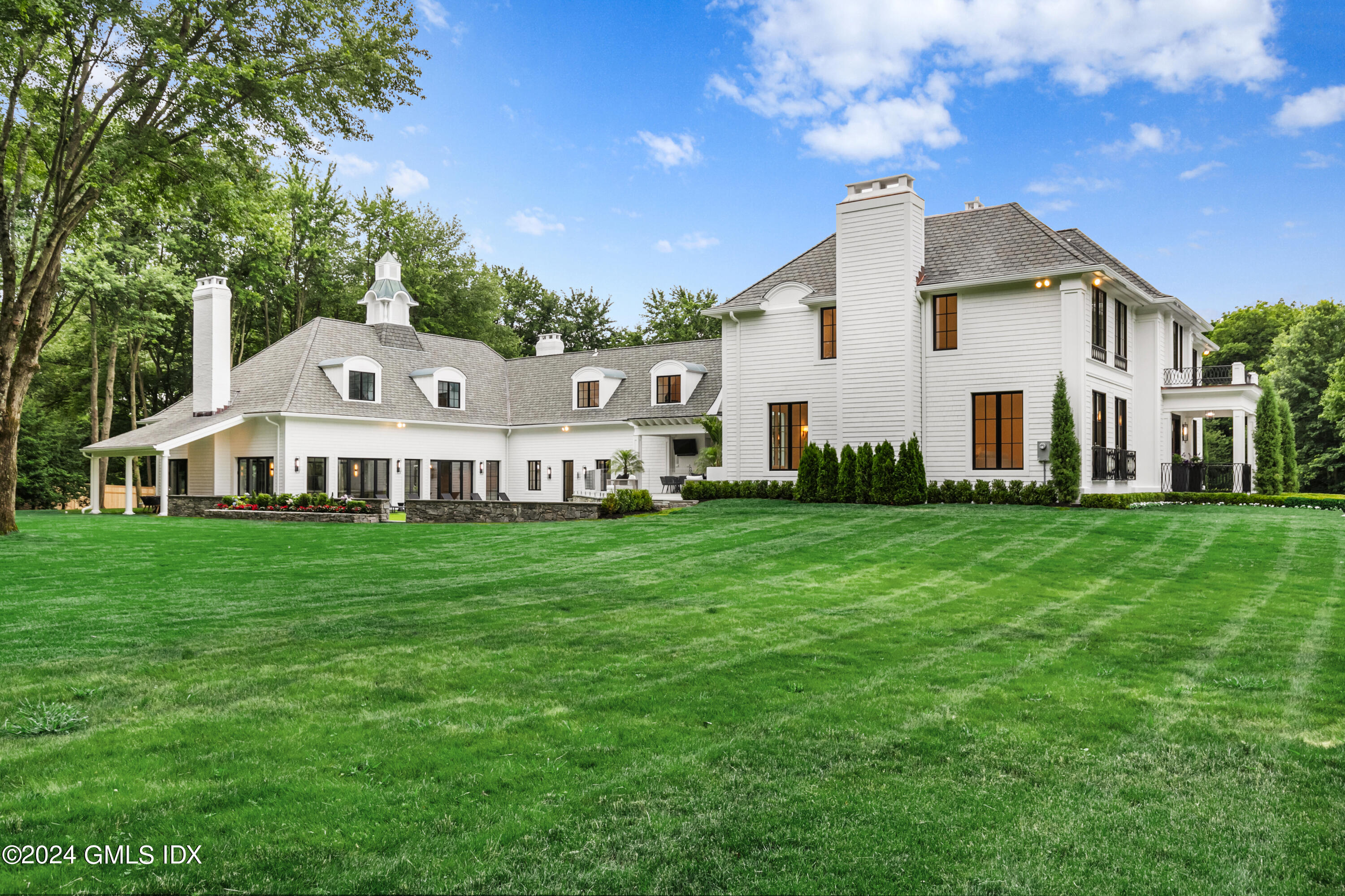 248 Round Hill Road Greenwich, CT 06831 - Photo 43 of 49 a front view of a house with a garden