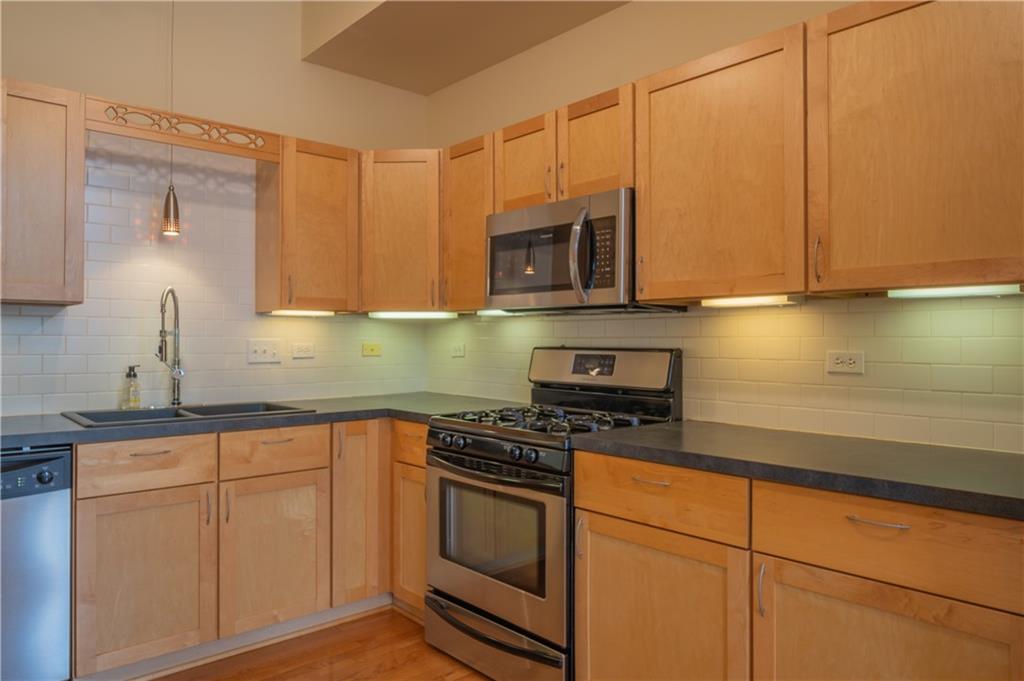 10 Walnut Street, Unit 6 Pittsburgh, PA 15202 - Photo 17 of 35 a kitchen with stainless steel appliances granite countertop a stove a sink and white cabinets