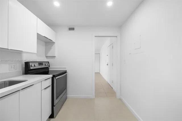 a kitchen with a sink and white cabinets