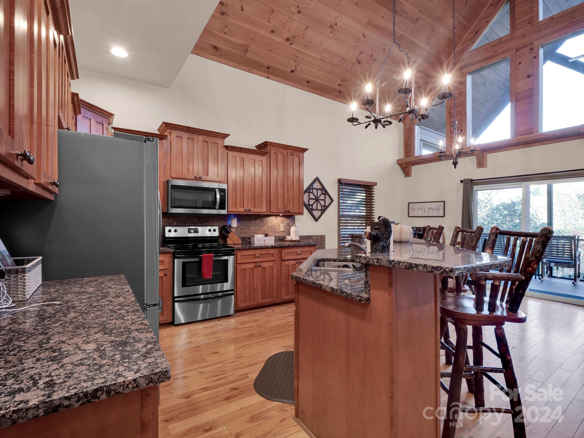 195 Grandview Mesa Road Whittier, NC 28789 - Photo 11 of 37 a kitchen with stainless steel appliances granite countertop a stove top oven a sink a dining table and chairs with wooden floor