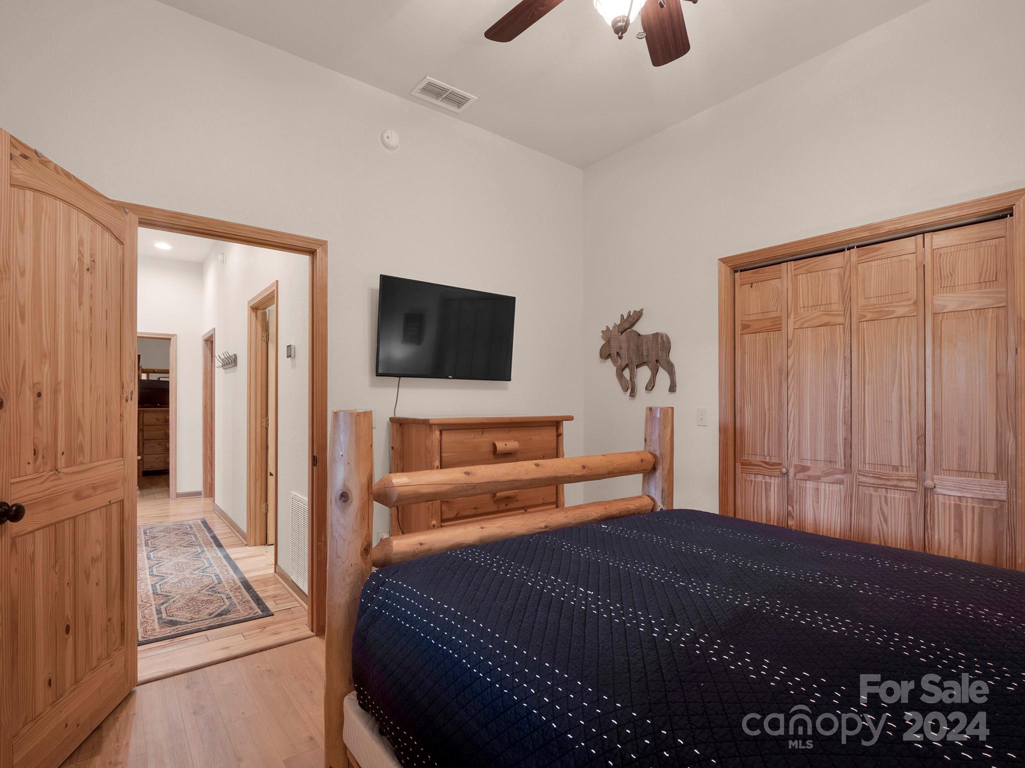 195 Grandview Mesa Road Whittier, NC 28789 - Photo 16 of 37 a bedroom with a bed and a flat tv screen on the dresser