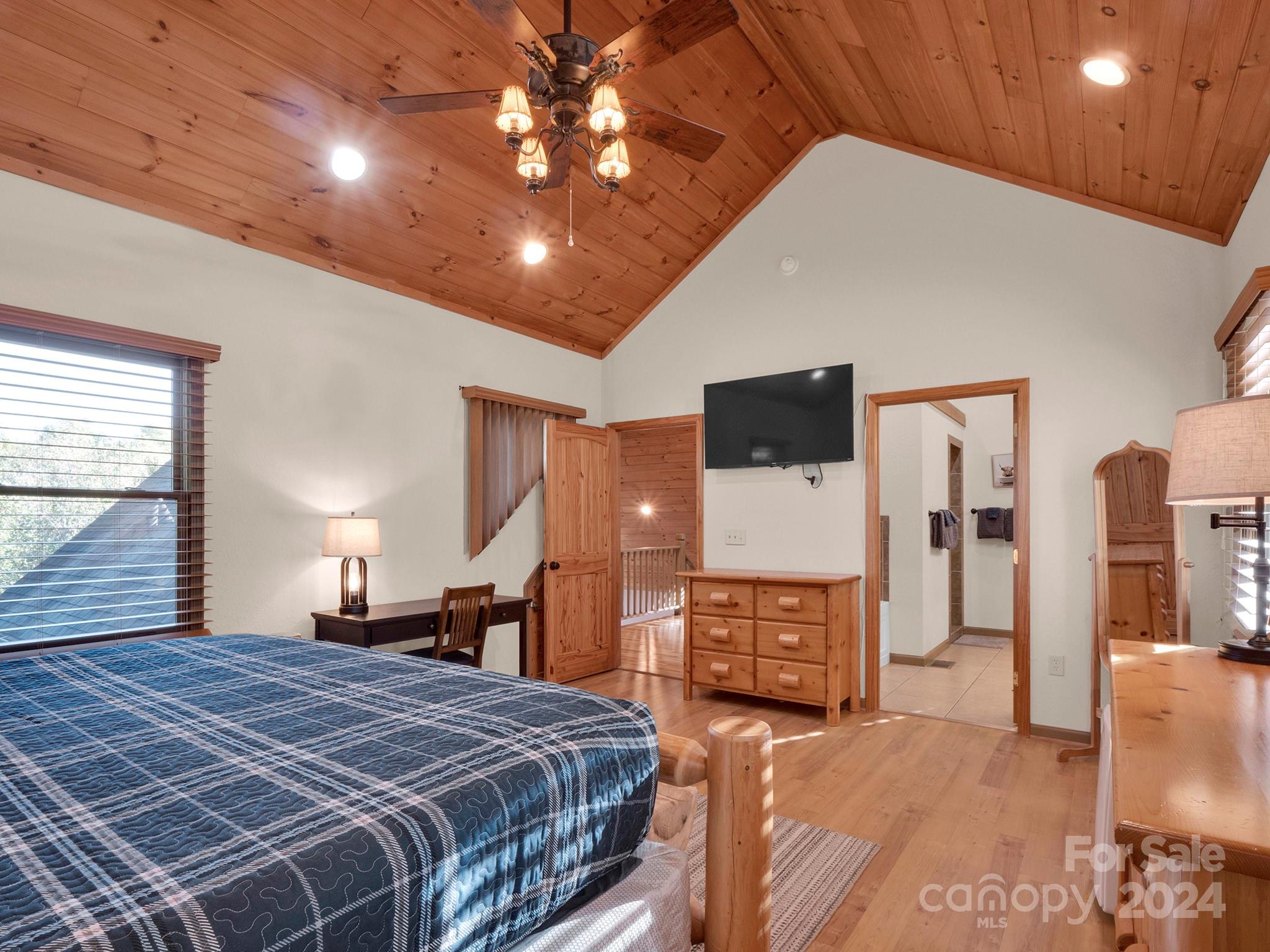 195 Grandview Mesa Road Whittier, NC 28789 - Photo 21 of 37 a bedroom with a bed a flat tv screen and dresser