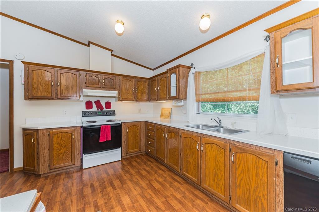 265 Pinecone Road Peachland, NC 28133 - Photo 11 of 35 a kitchen with stainless steel appliances granite countertop a sink and wooden cabinets with wooden floors