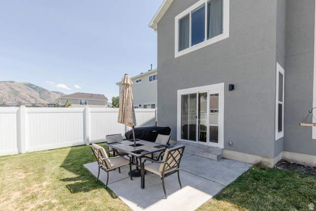 349 West 3085 South Logan, UT 84321 - Photo 30 of 37 Rear exterior featuring a concrete patio, a sliding glass door, and a white vinyl fence
