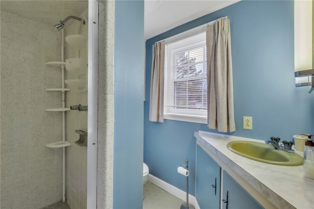 491 City Lake Road Pickens, SC 29671 - Photo 27 of 32 This bright bathroom features a vanity with a green sink, a shower stall, and natural light.