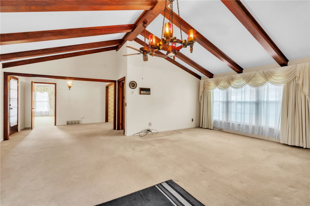 491 City Lake Road Pickens, SC 29671 - Photo 5 of 32 This expansive living space features a vaulted ceiling and exposed beams, creating an open and airy atmosphere.