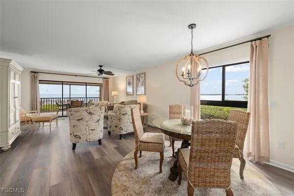 a dining room with furniture a chandelier and wooden floor