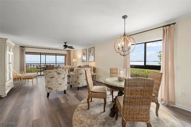a dining room with furniture a chandelier and wooden floor