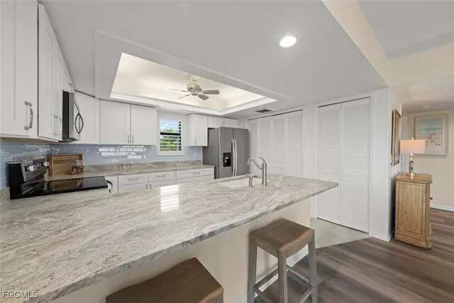 a kitchen with stainless steel appliances granite countertop a sink refrigerator and cabinets