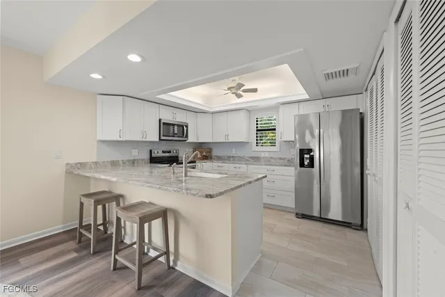 a kitchen with stainless steel appliances granite countertop a refrigerator and a stove top oven