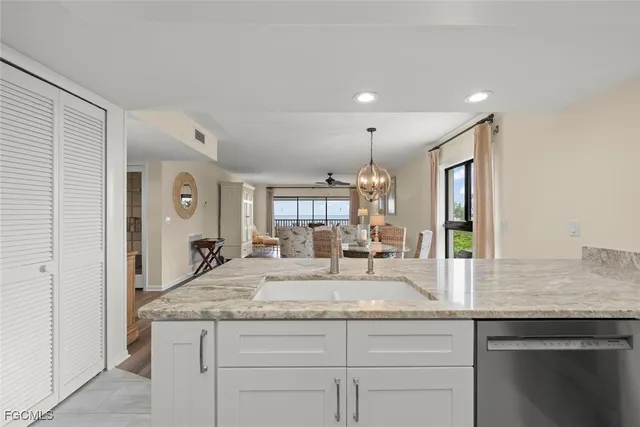 a kitchen with granite countertop kitchen island a sink and a stove with wooden floor